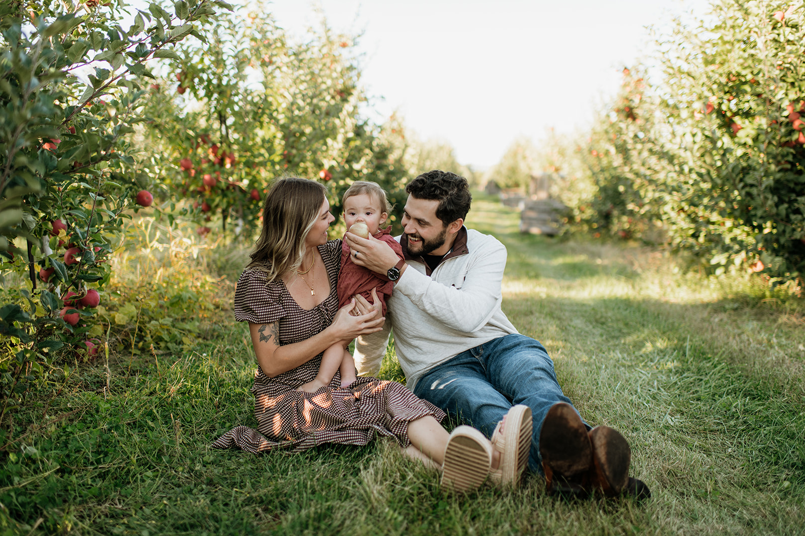 Family of three posing for their apple orchard family photos at Garwood Orchards - a Northern Indiana Photo Location.