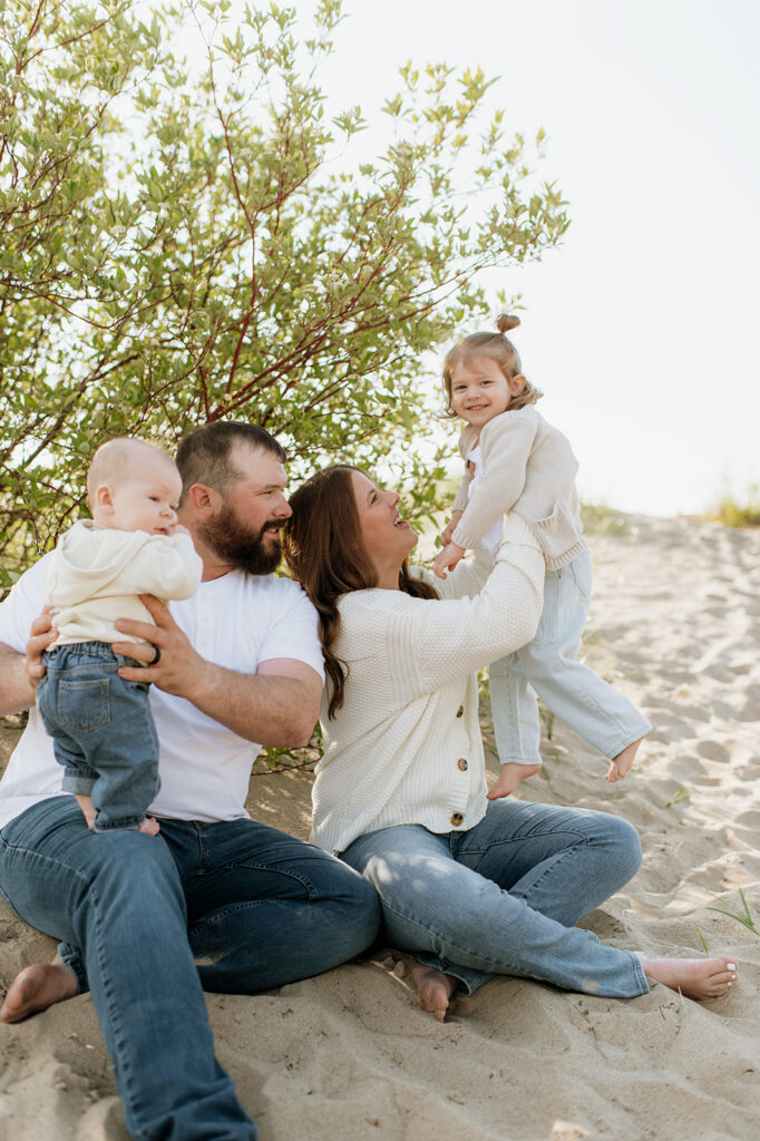 Family of four posing on the beach at New Buffalo Beach -  a Northern Indiana Photo Location.