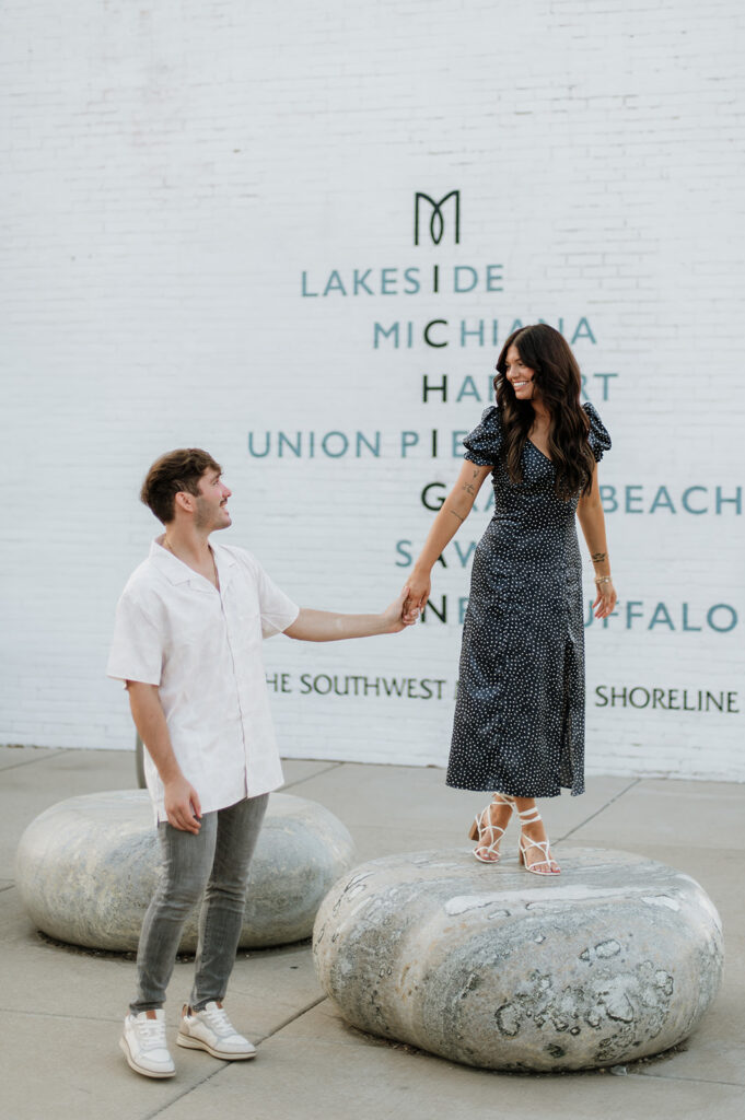 Couple holding hands and posing in New Buffalo for their engagement.