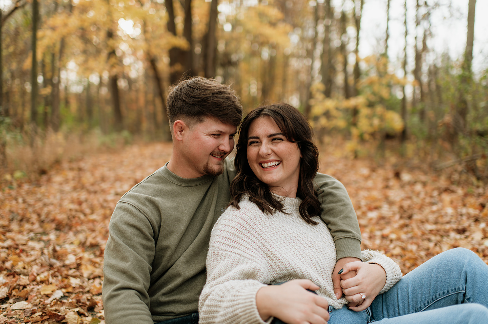 Couple laughing and sitting in the leaves at Potato Creek State Park - a Northern Indiana Photo Location.