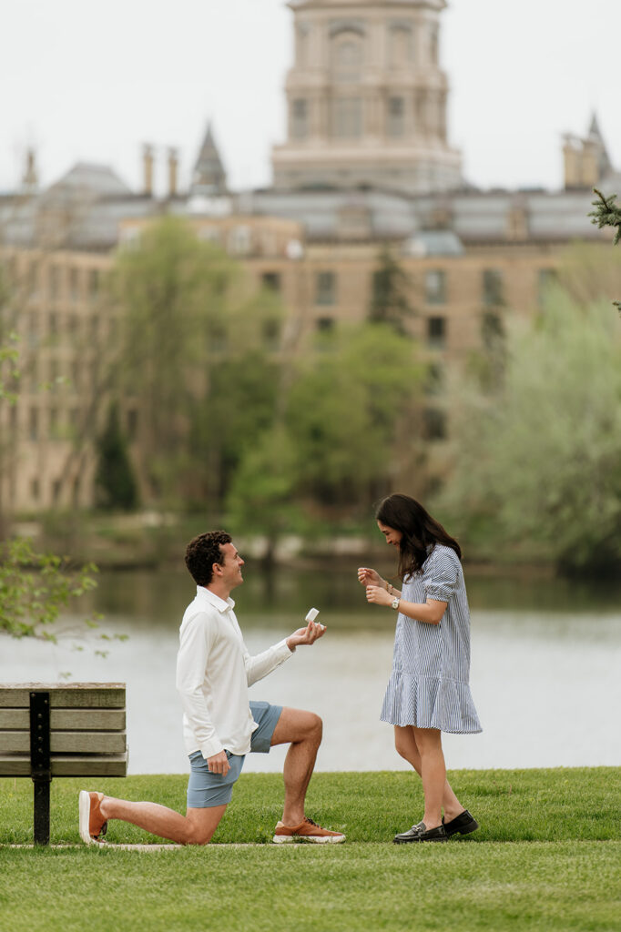 Man kneeling on one knee and proposing to his fiancé for their Notre Dame proposal at Saint Joseph's Lake.
