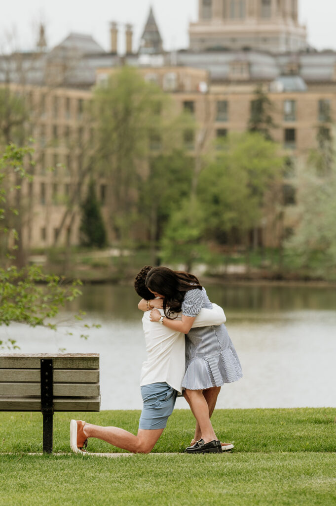 Woman hugging her fiancé after he proposed at Saint Joseph's Lake at The University of Notre Dame.