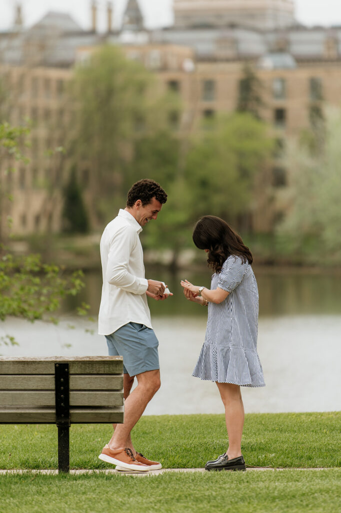 Woman admiring her engagement ring after her Notre Dame proposal in front of Saint Joseph's Lake.