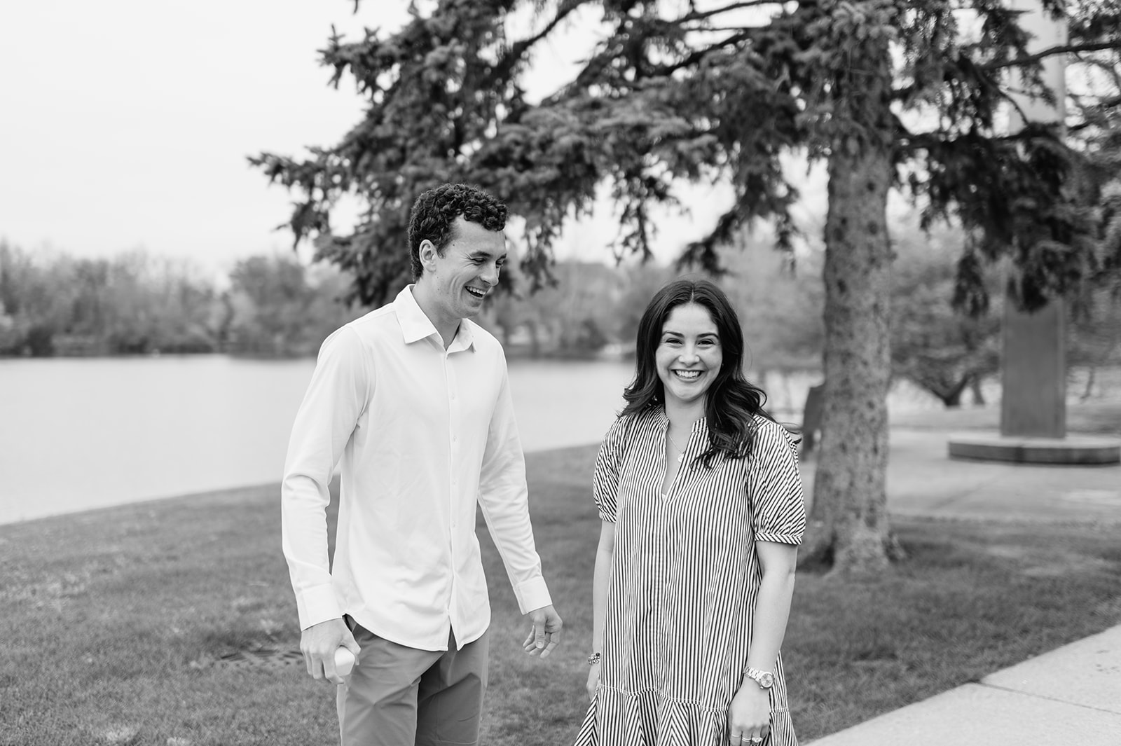 Black and white candid photo of a couple smiling after their surprise Notre Dame proposal.