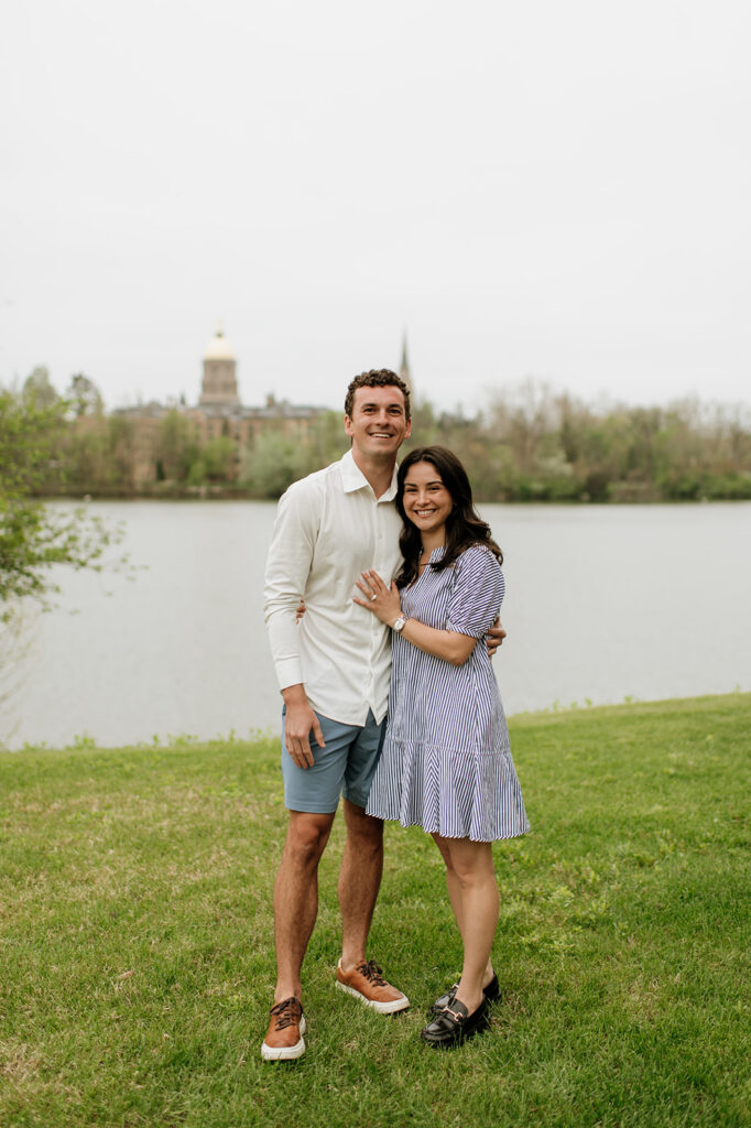 Man and woman posing in front of Saint Joseph's Lake for their Notre Dame proposal photos.