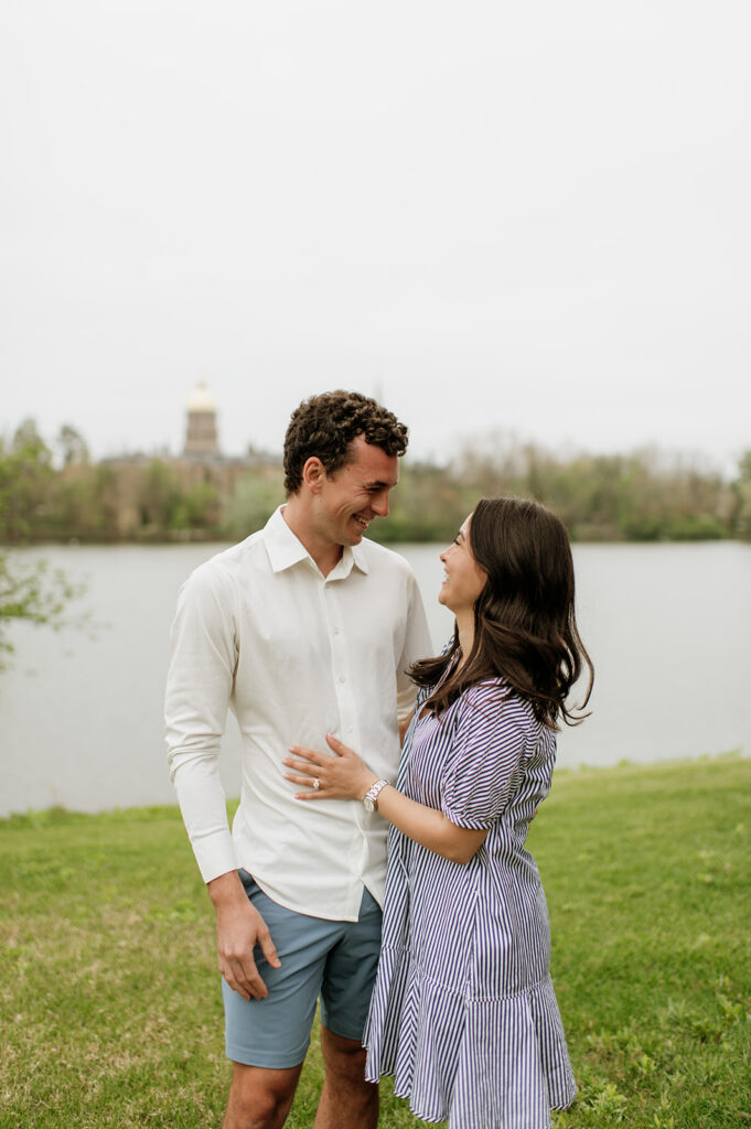 Man and woman posing in front of Saint Joseph's Lake for their Notre Dame proposal photos.