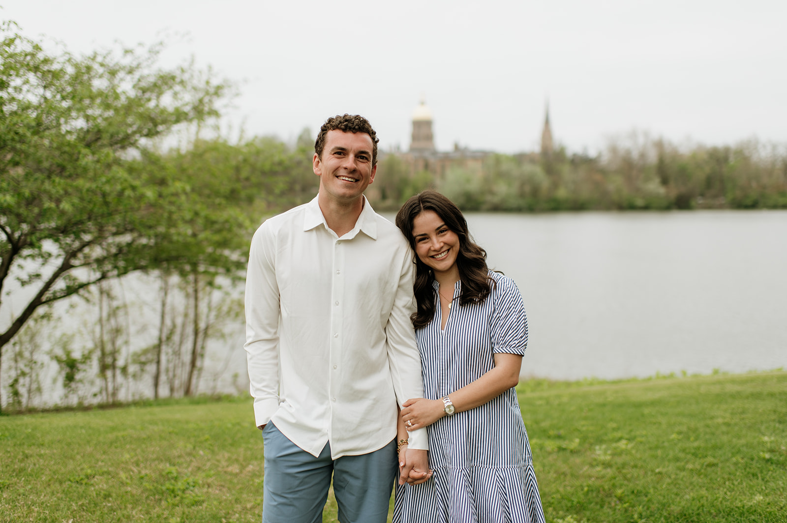 Man and woman posing in front of Saint Joseph's Lake for their Notre Dame proposal photos.