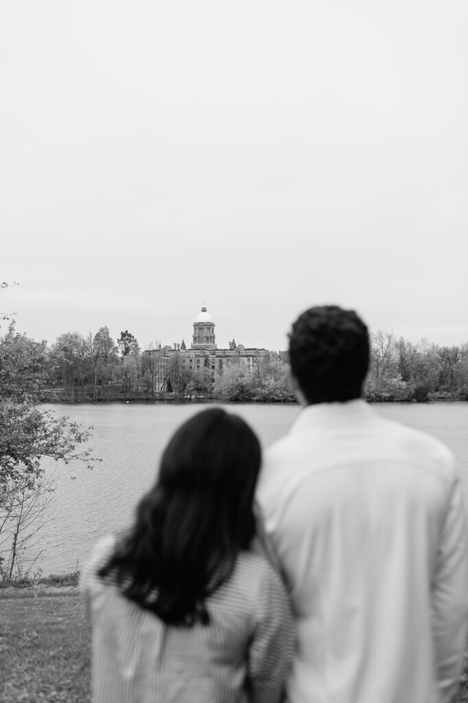 Black and white photo of a couple admiring the Golden Dome after their Notre Dame proposal.