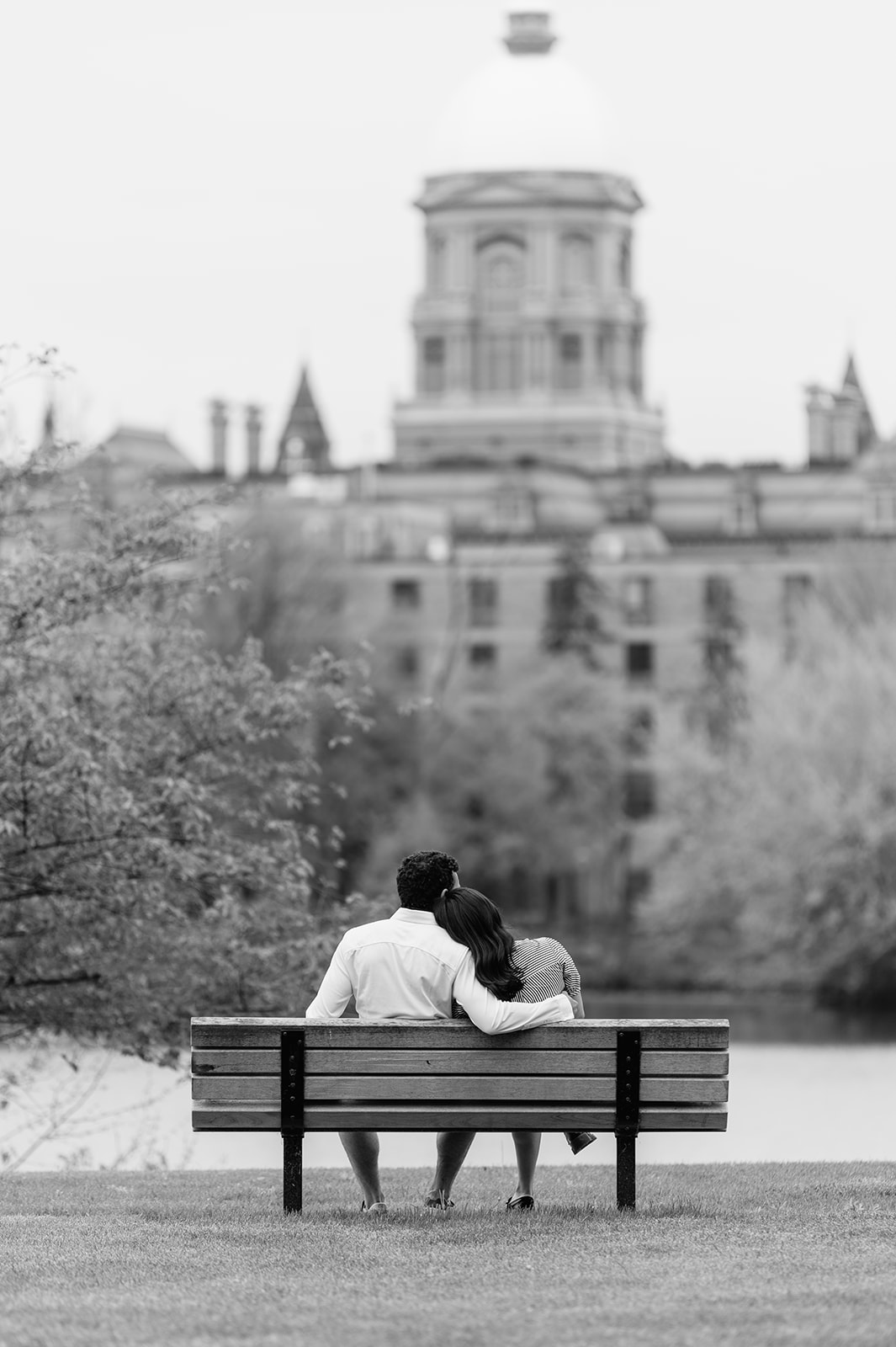 Black and white photo of a woman leaning her head on her boyfriends shoulder at Saint Joseph's Lake at University of Notre Dame.