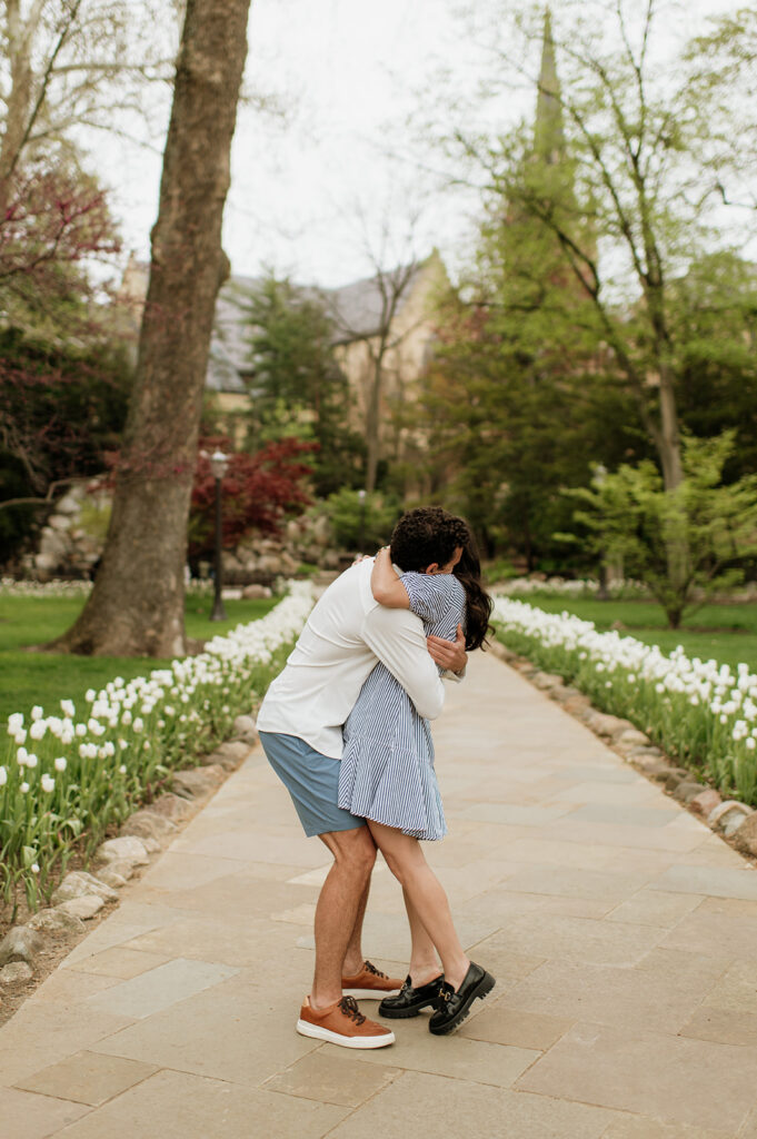 Man hugging his fiancé after their Notre Dame proposal near the Grotto.