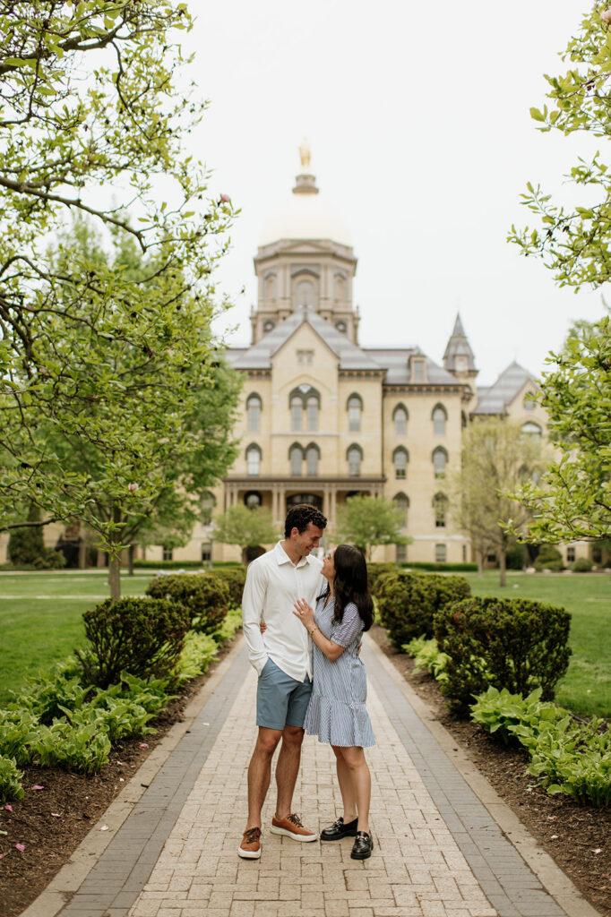 Man and posing posing in front of the main building and Golden Dome for their Notre Dame proposal photos.
