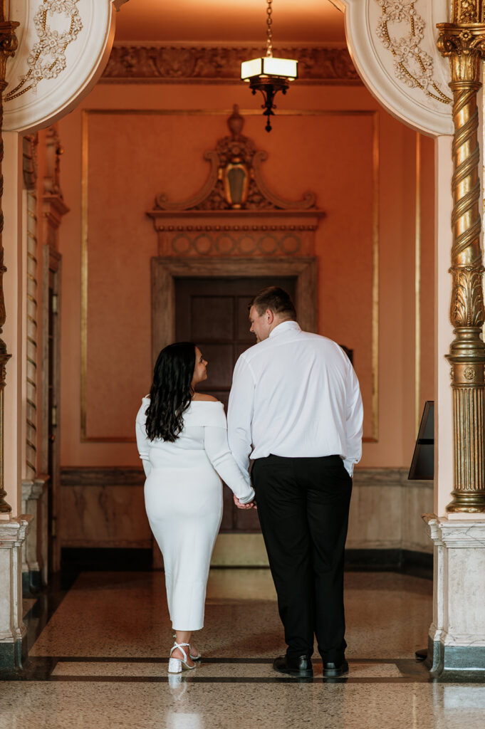 Couple walking inside Morris Performing Arts Center for their South Bend engagement photos.
