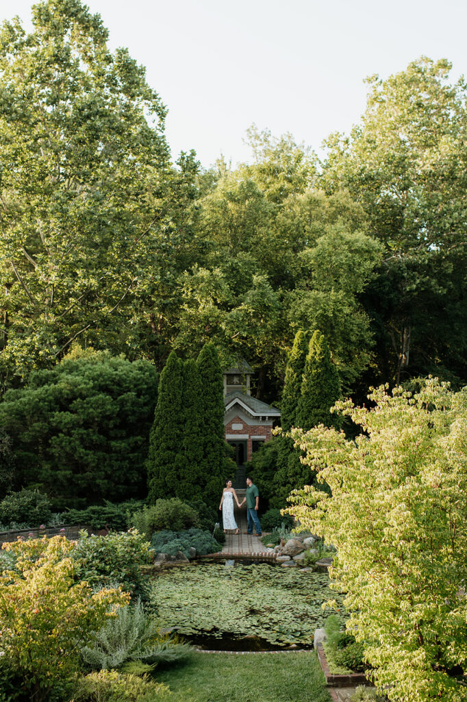 Couple walking in front of a pond at DeFries Gardens.