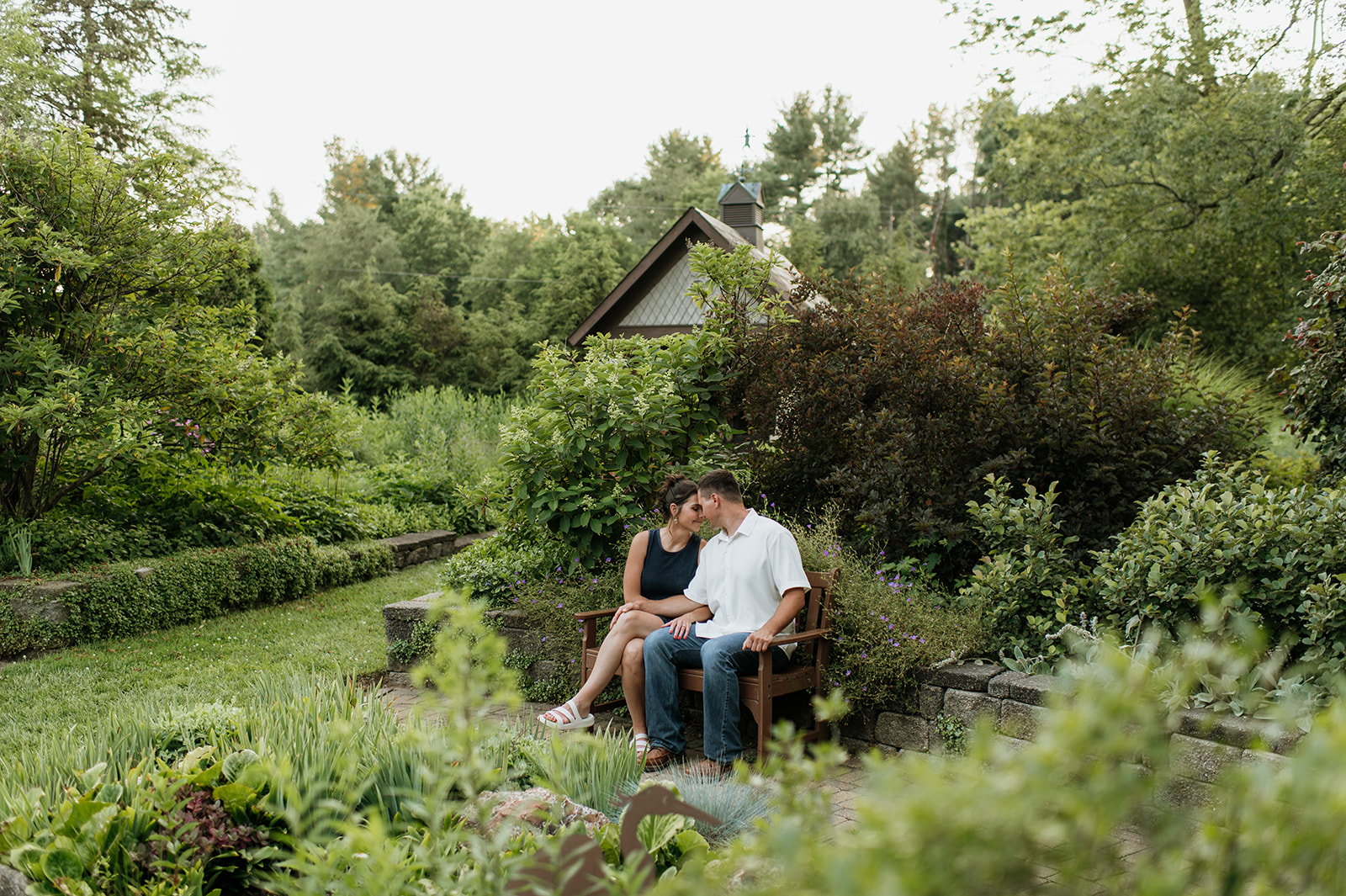Couple sitting on a bench at DeFries Gardens for their Northern Indiana engagement photos.