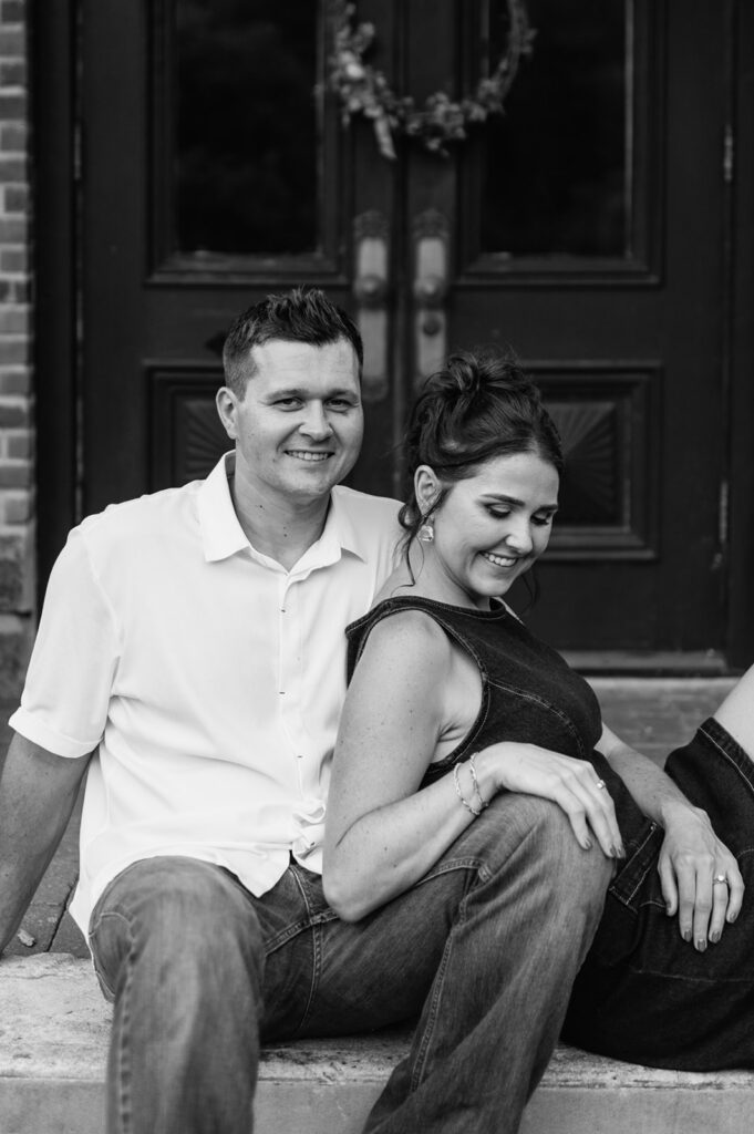 Black and white photo of a couple sitting together outside.