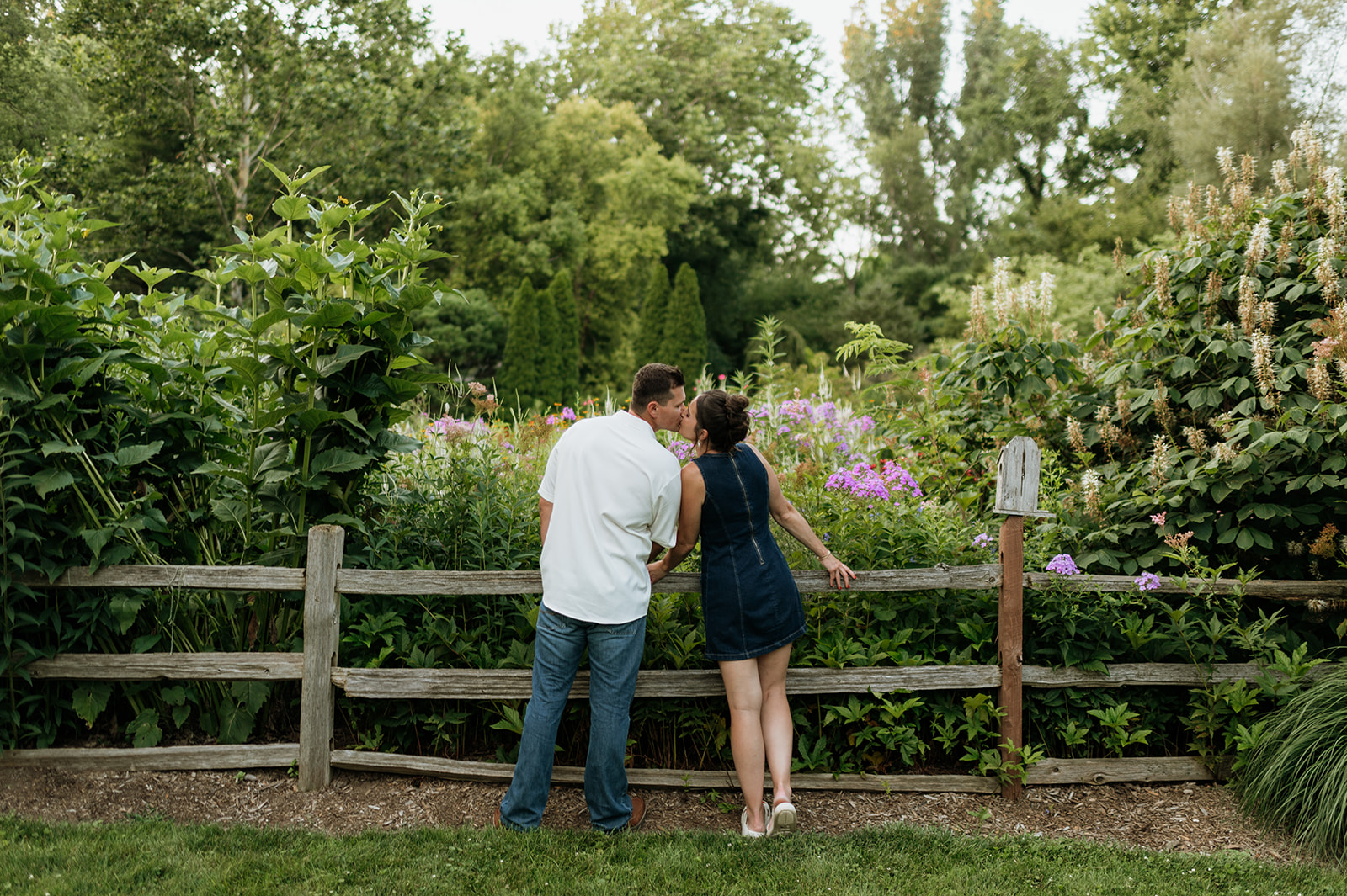 Couple kissing in front of a garden fence at Defries Gardens in New Paris, Indiana.