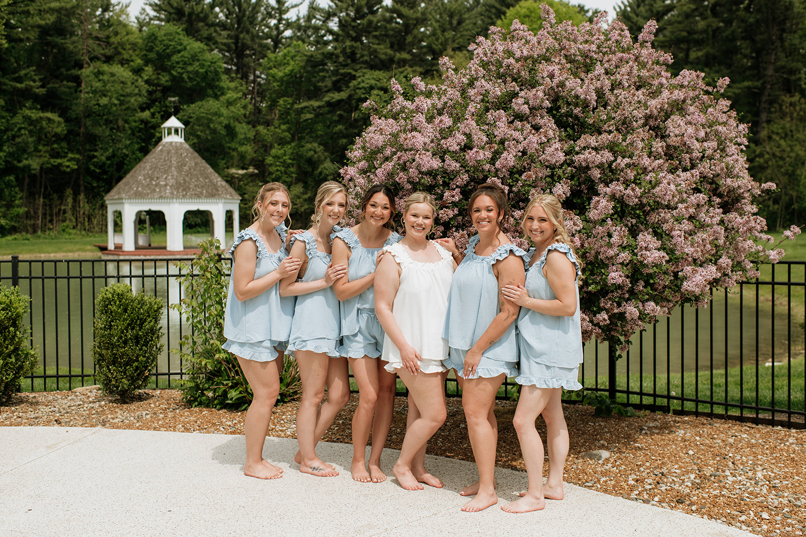 Bride and bridesmaids posing outside of The Blacksmith Lodge at The Morris Estate in Niles, Michigan.