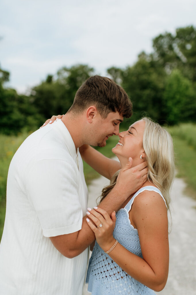 Man caressing his fiancés neck lovingly during their outdoor engagement session.