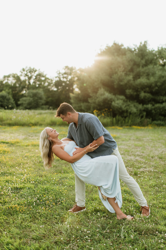 Man dipping his fiancé during their golden hour summer engagement photos in Elkhart, Indiana.