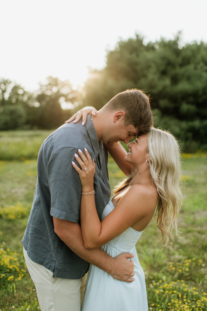 Couple touching foreheads during golden hour for their Cobus Creek County Park engagement photos near South Bend, Indiana.