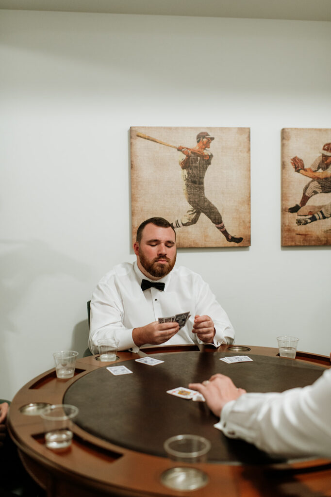 The groom playing poker inside the Grooms Lounge at The Morris Estate in Niles, Michigan.