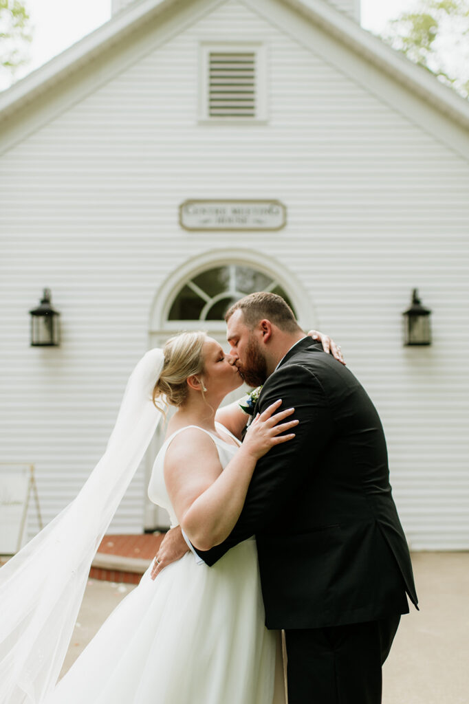 Bride and groom kissing in front of the chapel at The Morris Estate in Niles, Michigan.