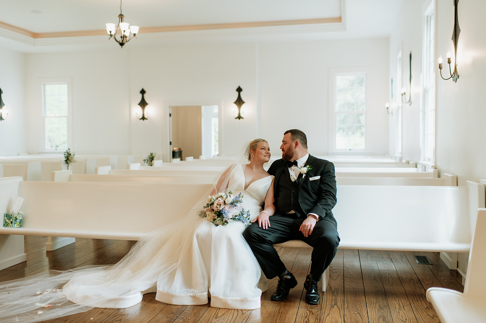 Bride and groom sitting together inside The Chapel at The Morris Estate in Niles, Michigan.