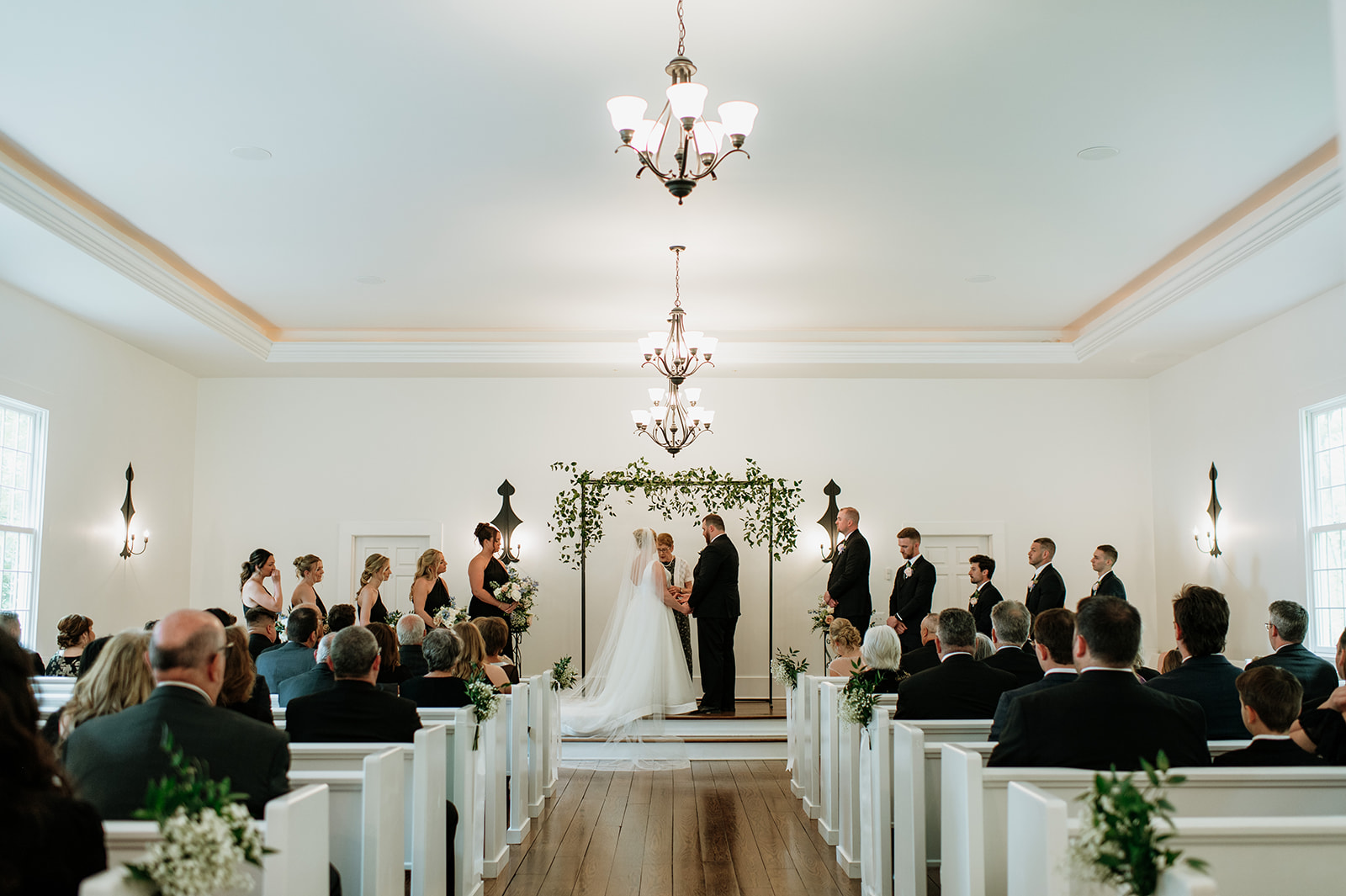 Bride and groom holding hands during their wedding at The Morris Estate's Chapel in Niles, Michigan.