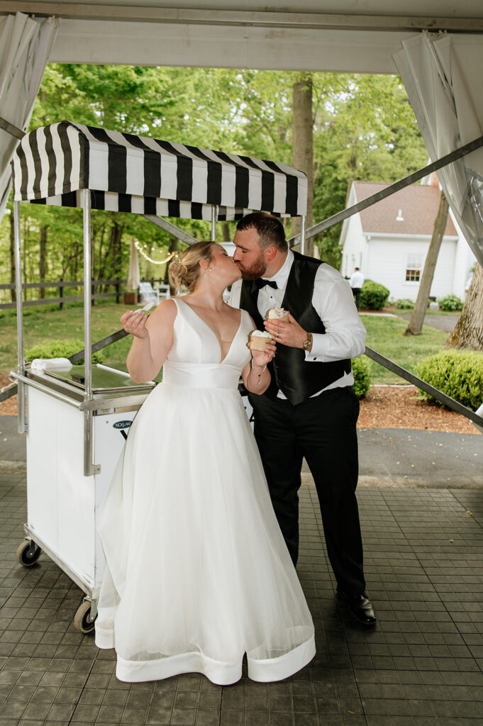 Bride and groom kissing with their ice cream.